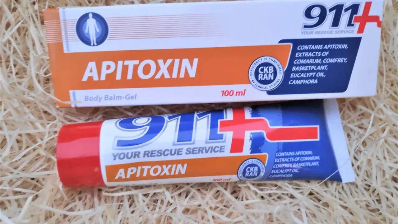 Dwa opakowania kremu z jadem pszczelim "Apitoxin" 911+ na tle słomy.
