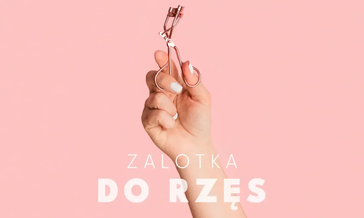 Dłoń trzyma zalotkę do rzęs. Czy zalotka niszczy rzęsy? Dowiedz się więcej o pielęgnacji.