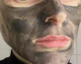 Twarz z nałożoną czarną maseczką rewitalizującą Avon. Skóra wokół ust i nosa jest odsłonięta.