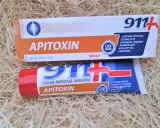 Dwa opakowania kremu z jadem pszczelim "Apitoxin" 911+ na tle słomy.