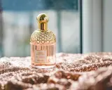 Elegancka butelka perfum Guerlain Aqua Allegoria Pera Granita na błyszczącym materiale. Czy na Notino są oryginalne perfumy? Tak, można znaleźć takie perełki.