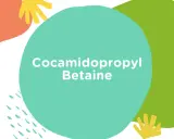 Kolorowe kształty na białym tle, z napisem "Cocamidopropyl Betaine". Składnik ten jest często używany w kosmetykach.