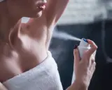 Kobieta aplikuje dezodorant pod pachę. Składnik butylphenyl methylpropional zapewnia długotrwałą świeżość.