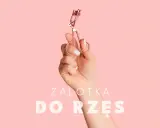 Dłoń trzyma zalotkę do rzęs. Czy zalotka niszczy rzęsy? Dowiedz się więcej o pielęgnacji.