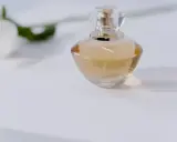 Elegancka butelka perfum na białym tle. Chcesz wiedzieć, jak sprawdzić, czy perfumy są oryginalne? Zwróć uwagę na detale.