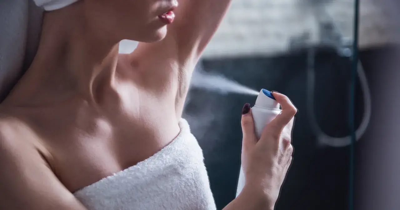 Kobieta aplikuje dezodorant pod pachę. Składnik butylphenyl methylpropional zapewnia długotrwałą świeżość.