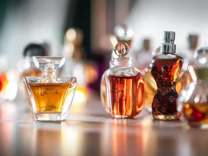 Kolekcja damskich perfum z lat 90. w szklanych flakonach, w tym Poeme Lancome i Dune Dior.