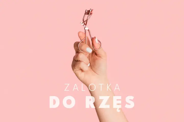 Dłoń trzyma zalotkę do rzęs. Czy zalotka niszczy rzęsy? Dowiedz się więcej o pielęgnacji.